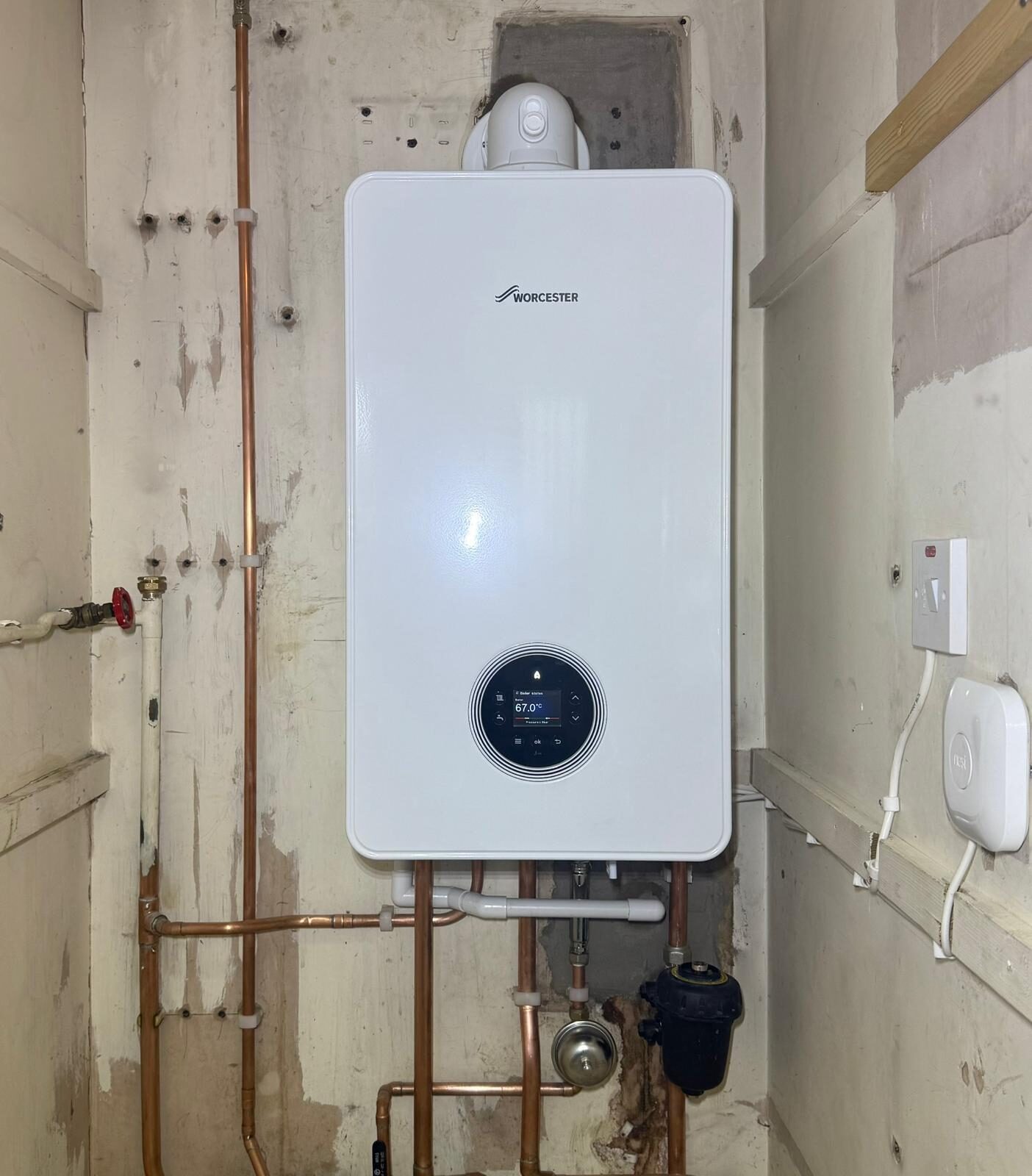 Modern wall-hung combi boiler installed by On-Tap Plumbing & Heating in Bedfordshire — clean white casing with circular digital display